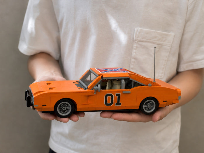 The finished General Lee model resting across two open hands, for scale